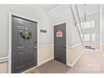 Hallway showing doors, carpet, and stairs with chandelier in this well-lit modern condo at 12357 Copper Mountain Blvd, Charlotte, NC 28277