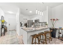 Bright kitchen features granite countertops, stainless steel appliances, modern fixtures, and breakfast bar at 12357 Copper Mountain Blvd, Charlotte, NC 28277