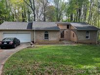Charming brick home featuring a two-car garage, well-maintained lawn, and inviting arched entryway at 137 Meadowbrook Ln, Davidson, NC 28036