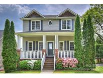 Charming two-story home featuring a welcoming front porch, beautiful landscaping, and classic architectural details at 1824 Hall Ave, Charlotte, NC 28205