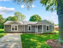 Charming one-story home with a well-manicured lawn, light gray siding, and a covered front porch at 3612 Cobbleridge Dr, Charlotte, NC 28215
