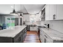 Modern kitchen with stainless steel appliances, white cabinets, and marble countertops at 3612 Cobbleridge Dr, Charlotte, NC 28215
