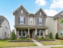 Charming two-story home with a welcoming front porch and well-maintained landscaping at 6433 Raffia Rd, Charlotte, NC 28277