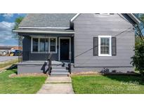 Charming home featuring a covered front porch with classic black railing and gray painted steps at 71 14Th Se St, Hickory, NC 28602