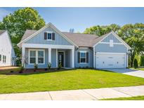 Charming one-story home with blue siding, well-manicured lawn, and attached two-car garage at 7185 Chamberlain Dr, Harrisburg, NC 28075