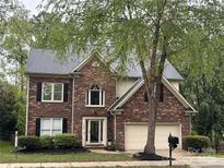 Charming two-story brick home with an attached two-car garage and well-manicured landscaping at 7409 Tarland Ln, Charlotte, NC 28269