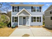 Charming two-story home with a light blue exterior, black shutters, and inviting front porch and well manicured lawn at 76 Snyder Ne Ct, Concord, NC 28025