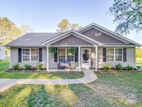 Charming single-story home with inviting front porch, beautiful landscaping, and a welcoming entrance at 833 Generation Ln, Clover, SC 29710