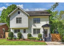 Charming two-story home featuring a landscaped front yard with well-manicured bushes and a covered front porch at 908 Academy St, Charlotte, NC 28205