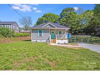 Charming single-story home with a small front porch, vibrant turquoise door and shutters, and a well-maintained lawn at 221 River Loop Rd, Belmont, NC 28012