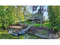 Beautiful two-story gray home with landscaped yard and private dock on a wooded waterfront lot at 3915 Chevlot Hills Rd, Sherrills Ford, NC 28673