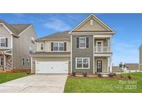 Charming two-story home featuring a mix of siding, attached two car garage, and a well-manicured lawn at 4222 Skyboat Cir, Fort Mill, SC 29715