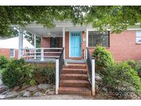 Charming brick home with a cozy front porch and a bright blue front door at 516 Northgate Ave, Charlotte, NC 28209