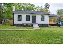 Charming home featuring a well-manicured lawn, covered parking, and a classic white exterior with black trim at 601 Whisnant St, Shelby, NC 28150
