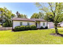 Charming single-story home featuring mature landscaping and a detached garage at 8210 Lantana Dr, Denver, NC 28037
