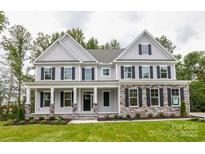 Charming two-story home features stone accents, a covered porch, black shutters and manicured lawn at Tbd Boomer Ct # 6, Statesville, NC 28677