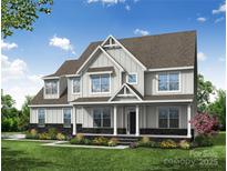 Beautiful two-story home featuring white siding, covered porch, meticulous landscaping, and a well-manicured lawn at Tbd Boomer Ct # 7, Statesville, NC 28677
