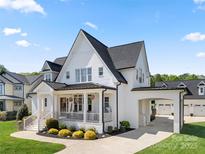 Stunning white two-story home with black roof, inviting front porch, and manicured lawn at 11015 Benjamin Smith Ave, Huntersville, NC 28078