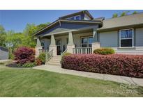 Charming home featuring a welcoming front porch, well-manicured landscaping, and mature trees at 1306 Kings Bottom Dr, Fort Mill, SC 29715