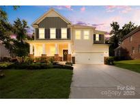 Charming two-story home with a well-manicured lawn, inviting front porch, and a two-car garage at 17413 Caddy Ct, Charlotte, NC 28278
