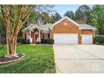 Charming brick home features an attached garage and well-manicured front lawn at 212 Kilborne Rd, Mooresville, NC 28117