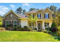 Charming two-story home with a stone facade, landscaped yard, shutters, and inviting front porch at 404 Brookridge Dr, Mount Holly, NC 28120
