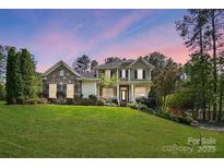 Charming two-story home featuring a stone facade, inviting porch, and a lush green lawn at 404 Brookridge Dr, Mount Holly, NC 28120