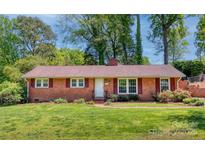 Charming brick home with red shutters and a well-manicured lawn and landscaping at 4925 Seacroft Rd, Charlotte, NC 28210