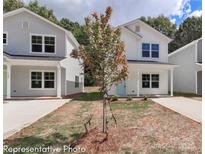 Charming two-story home featuring light-colored siding, double-hung windows, and a welcoming front porch at 556 Ridge Ave, Mooresville, NC 28115