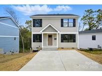 Charming two-story home showcasing neutral siding, black shutters, and a well-manicured front yard at 74 Snyder Ne Ct, Concord, NC 28025