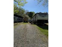 RV sitting on a lot with gravel parking and a small storage shed behind at 103 Hidaway Trl # 99A, Mount Gilead, NC 27306