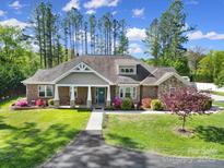 Beautiful single-story home with manicured lawn, brick and stone accents, and a welcoming front porch at 10416 Glenmac Rd, Charlotte, NC 28215