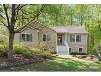 Charming two-story home featuring stone accents, complemented by lush greenery and a welcoming front entrance at 109 Wren Ln, Mooresville, NC 28117