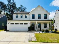 Charming two-story white home featuring a two-car garage, inviting front porch, and landscaped front yard at 1408 Augustus Beamon Dr, Charlotte, NC 28079
