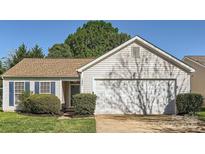 Charming single-story home with well-maintained landscaping and a two-car garage at 1807 Oakdale Green Dr, Charlotte, NC 28216