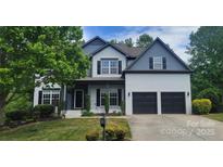 Charming two-story home with a well-maintained lawn, a two car garage, and traditional architectural details at 1811 Robbins Meadows Dr, Waxhaw, NC 28173