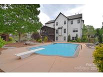 Inviting pool with diving board alongside a spacious backyard and screened in porch at 1811 Robbins Meadows Dr, Waxhaw, NC 28173