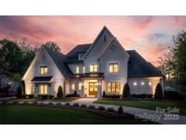 Stunning white brick home with manicured lawn, welcoming entrance, and a lovely dusk sky at 1976 Ferncliff Rd, Charlotte, NC 28211