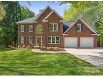 Traditional brick home with a two-car garage and manicured lawn featuring new landscaping at 210 35Th Ne Ave, Hickory, NC 28601