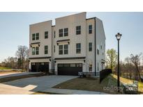 Modern townhome featuring a three-story design with a black two-car garage at 2124 Barrowcliffe Nw Dr, Concord, NC 28027