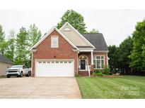 Charming brick home featuring a two-car garage and well-manicured lawn at 260 Ingonish Dr, Gastonia, NC 28056