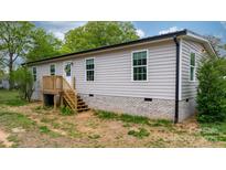 Charming single-story home with light gray siding, white trim, and a welcoming front entrance at 261 8Th Avenue Se Dr, Hickory, NC 28602