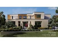 Modern home featuring a dramatic courtyard entry and contemporary stucco, siding, and black trim window design at 3630 Foxcroft Rd, Charlotte, NC 28211