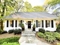 Charming home featuring a beautifully landscaped front yard, black shutters, and a welcoming stone pathway at 3718 Barclay Downs Dr, Charlotte, NC 28209