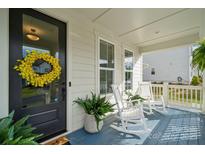 Charming covered front porch with rocking chairs, plants, and a welcoming wreath on the front door at 4012 Spring Cove Way, Belmont, NC 28012
