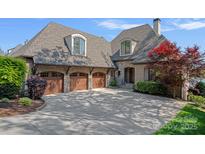 Stunning brick home with a three-car garage and manicured landscaping, offering a luxurious curb appeal at 4109 Arbor Spring Ct, Belmont, NC 28012