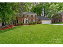 Charming two-story brick home with a well-manicured lawn and mature trees at 6634 Rocky Falls Rd, Charlotte, NC 28211