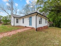 Charming home with a brick pathway leading to the light blue front door and white siding at 721 Broad St, Kannapolis, NC 28081