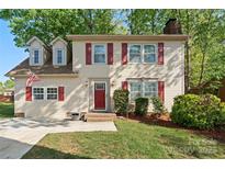 Charming two-story home features dormer windows, red shutters, brick steps, and a well-manicured lawn at 7220 Spring Morning Ln, Charlotte, NC 28227
