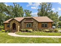 Charming home featuring a stone facade, meticulously landscaped yard, and classic architectural details at 8835 Glencroft Rd, Mint Hill, NC 28227